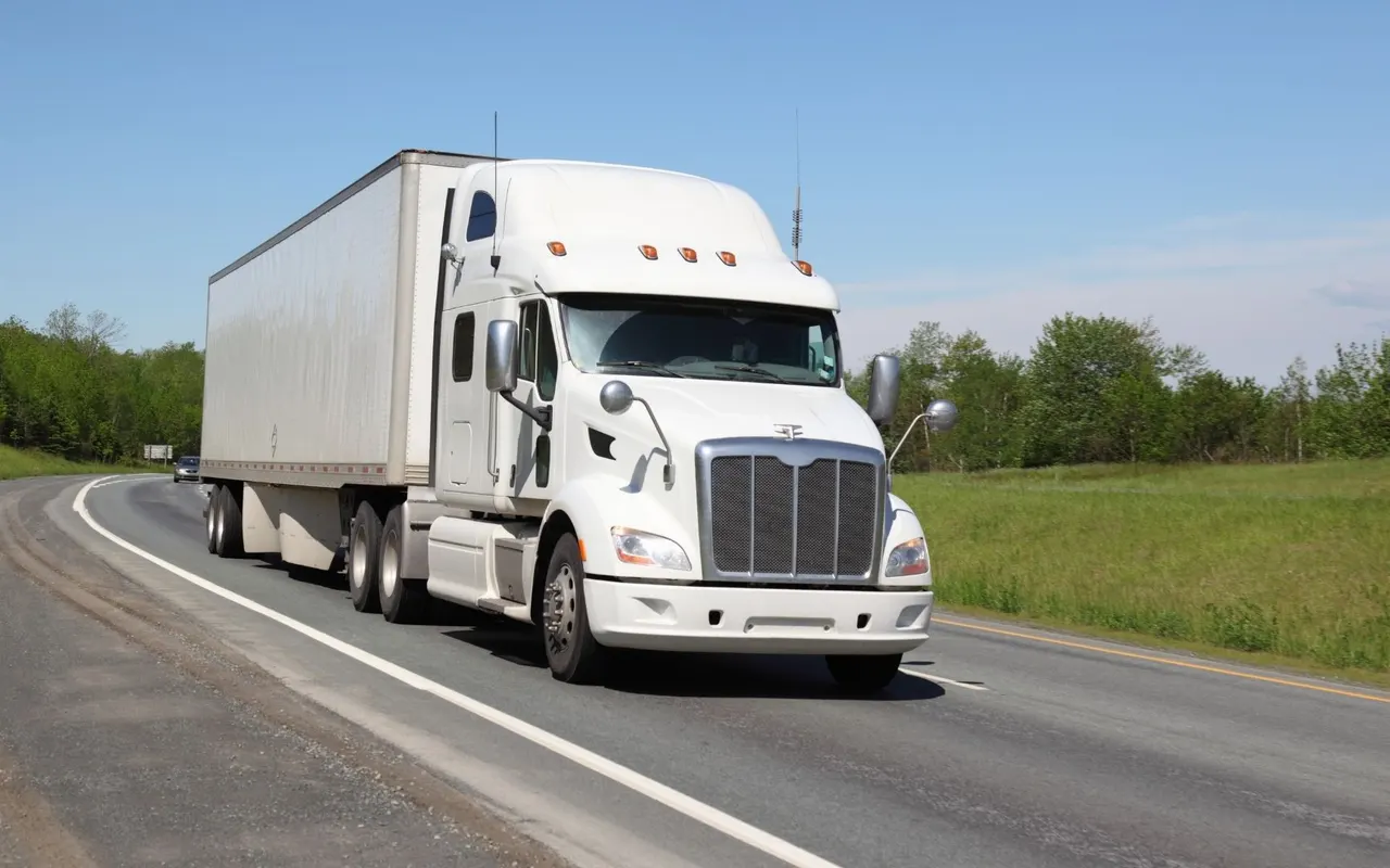 White semi truck and trailer on a highway shoulder