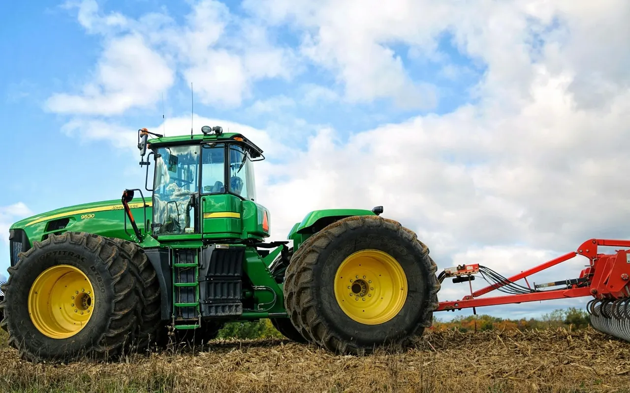 Large John Deere tractor working a field