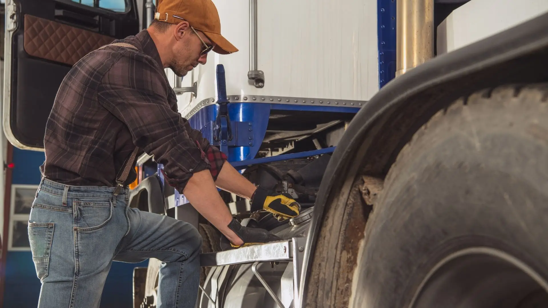 Mechanic working on the wheel area of a commercial trailer
