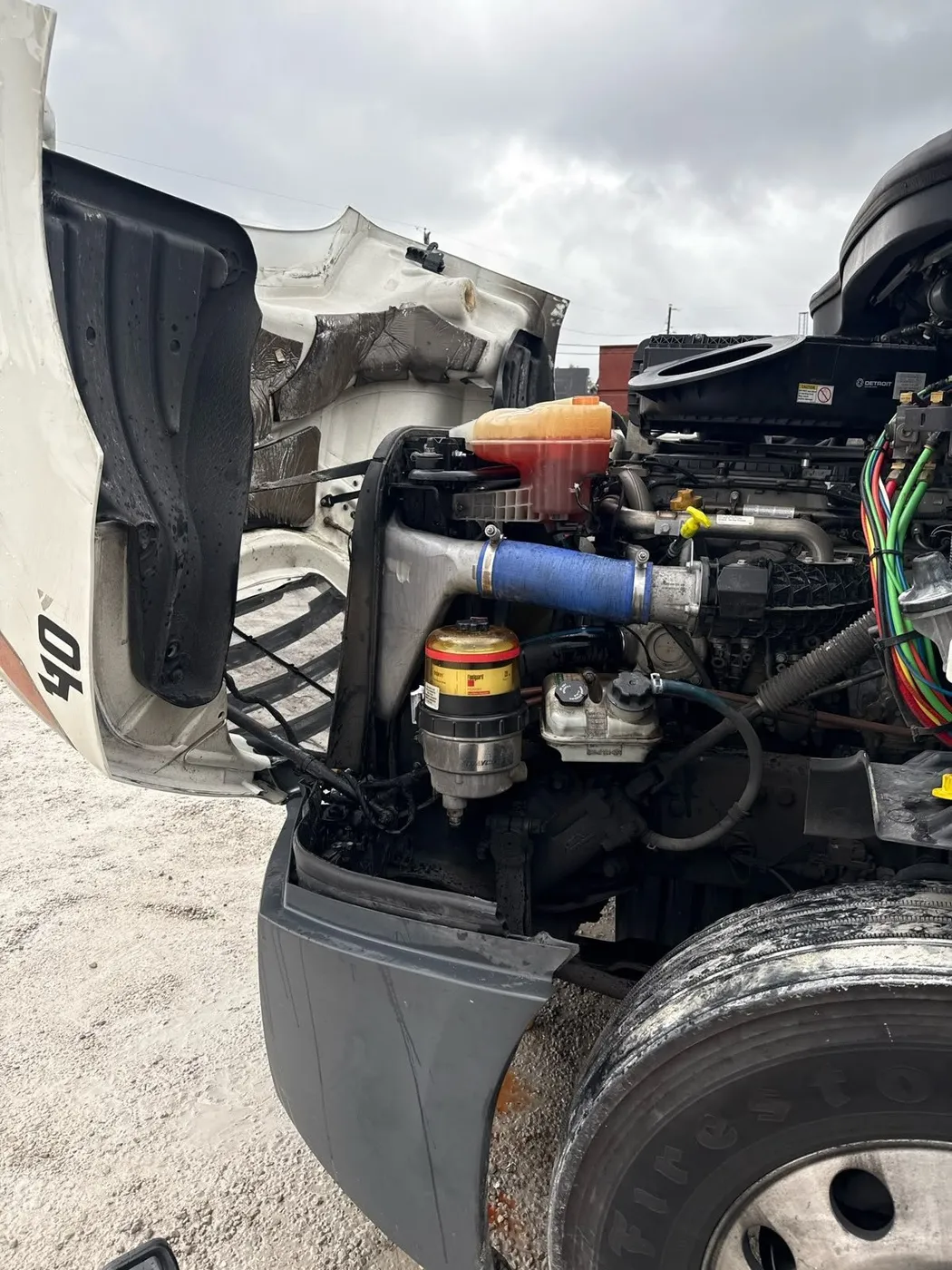 Technician servicing a semi truck engine at the roadside