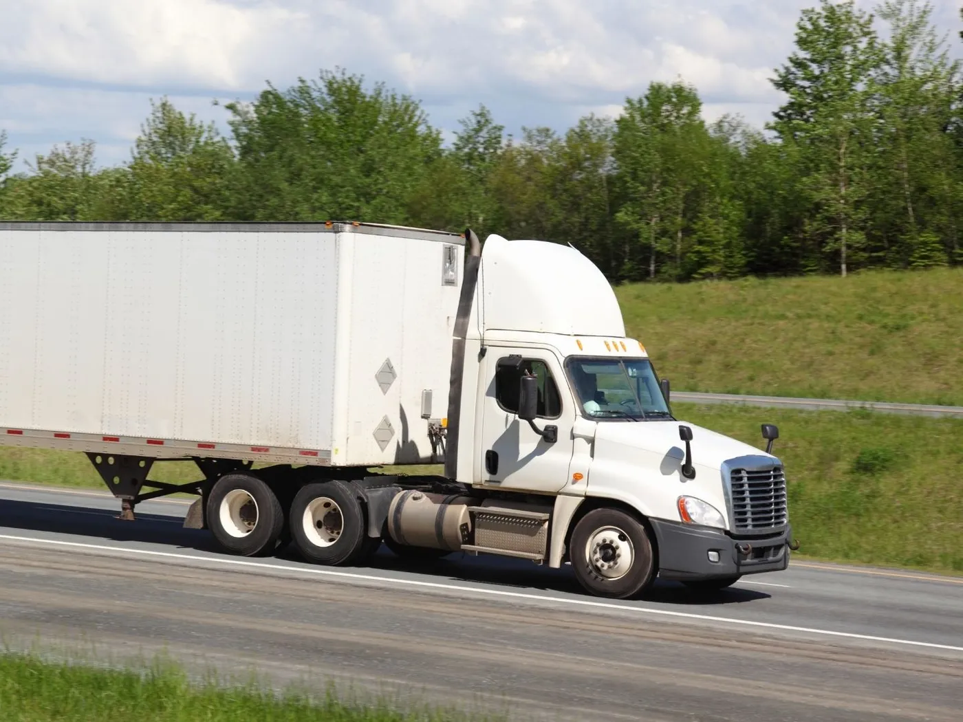 Semi truck and trailer stopped alongside a rural highway